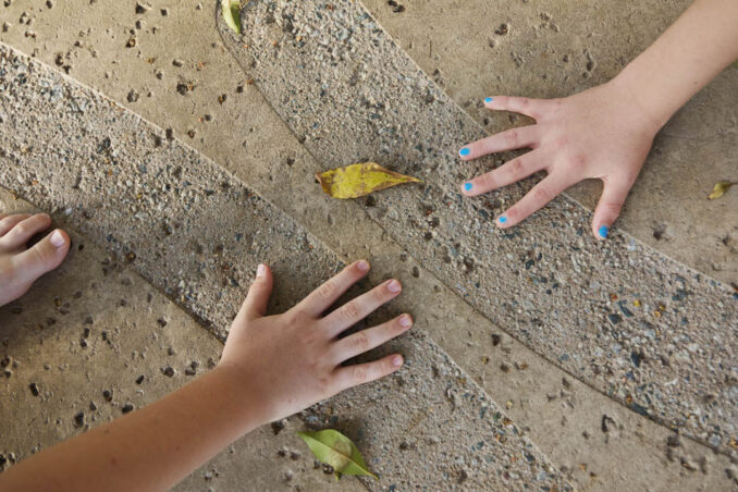 Children's hands on concrete pattern - neurodiverse design